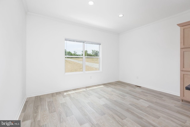 empty room featuring light hardwood / wood-style floors and ornamental molding