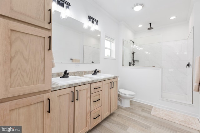 bathroom featuring crown molding, hardwood / wood-style floors, toilet, tiled shower, and vanity