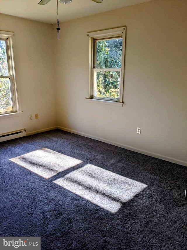 carpeted spare room with ceiling fan and a baseboard heating unit