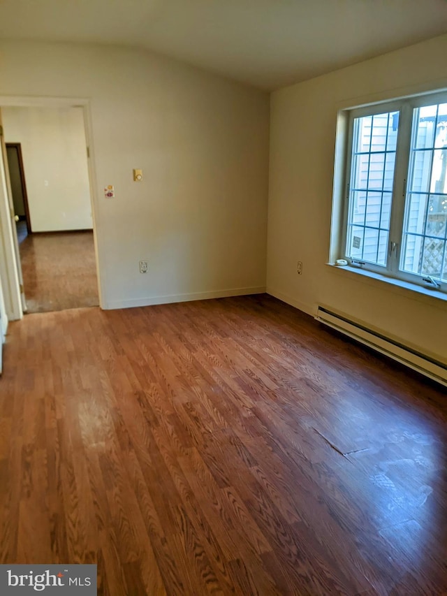 spare room with baseboard heating and hardwood / wood-style floors