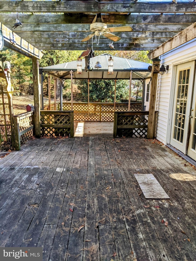 wooden deck with ceiling fan, a gazebo, and a pergola