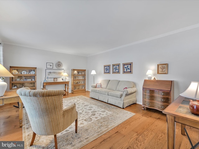 living room with light wood-type flooring and ornamental molding