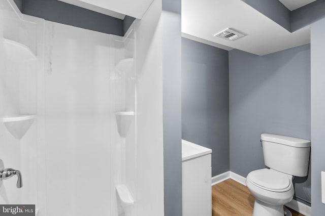 bathroom featuring hardwood / wood-style floors, toilet, and walk in shower