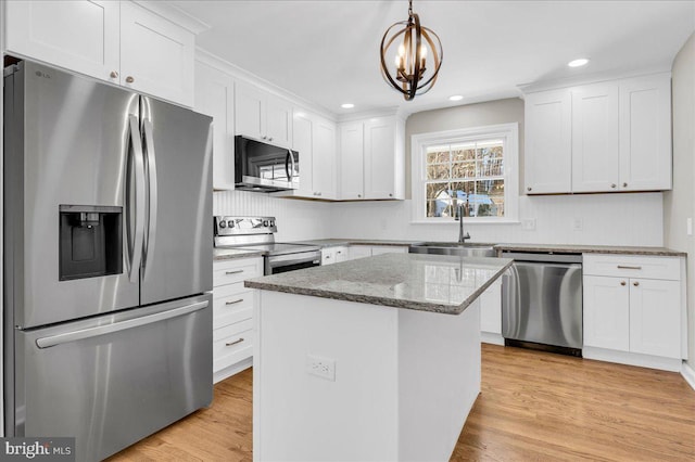 kitchen featuring sink, hanging light fixtures, a kitchen island, white cabinetry, and stainless steel appliances