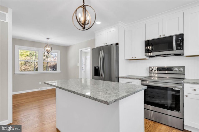 kitchen with white cabinetry, hanging light fixtures, a notable chandelier, and appliances with stainless steel finishes