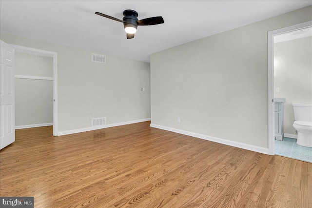 unfurnished bedroom with ceiling fan, a closet, connected bathroom, and light hardwood / wood-style flooring