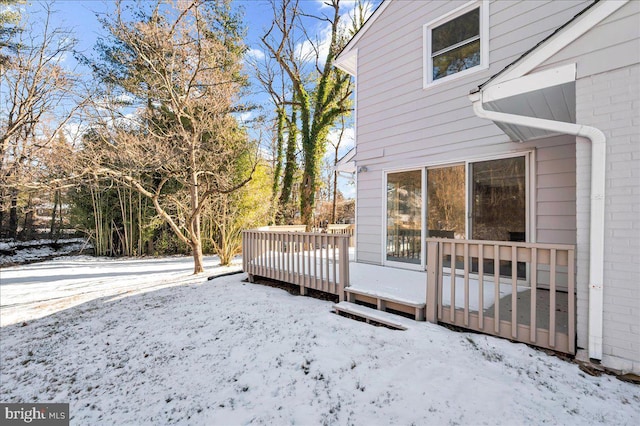 view of snowy exterior featuring a wooden deck