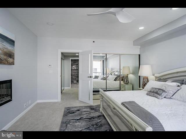 carpeted bedroom featuring ceiling fan and a closet