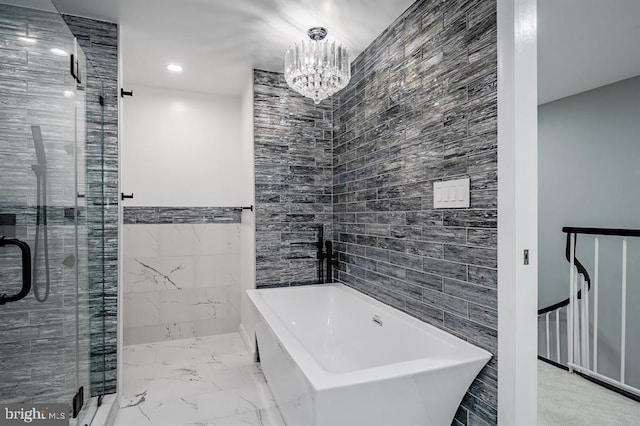 bathroom with a chandelier, independent shower and bath, and tile walls