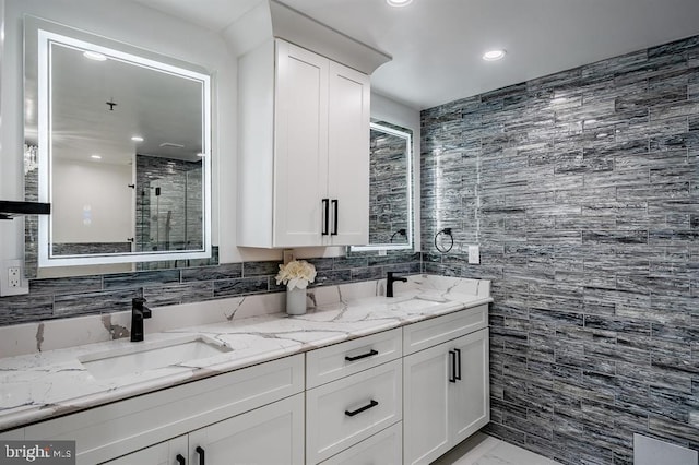 bathroom with tile walls, vanity, and an enclosed shower