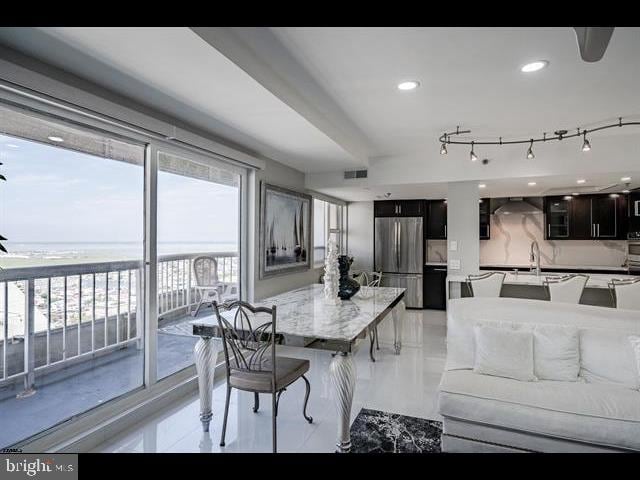 dining room featuring rail lighting, a water view, and sink