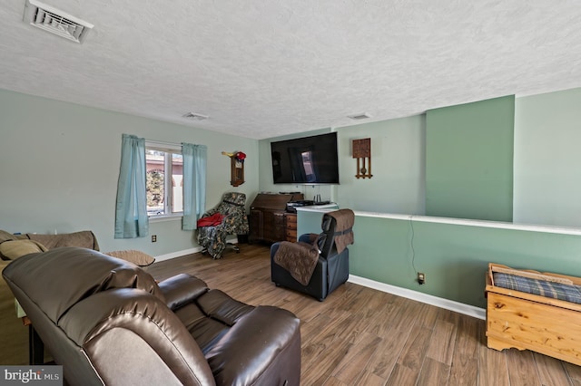 living room featuring a textured ceiling and wood-type flooring