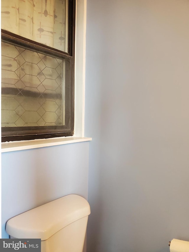 bathroom with backsplash and toilet