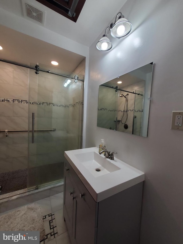 bathroom featuring an enclosed shower, vanity, and tile patterned flooring