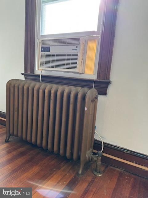 room details with wood-type flooring and radiator heating unit