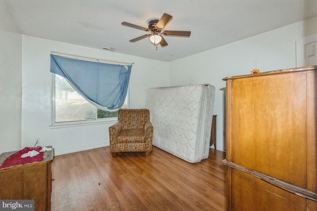 sitting room featuring hardwood / wood-style floors and ceiling fan