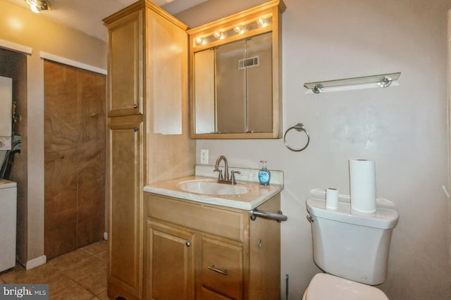 bathroom featuring vanity, tile patterned flooring, and toilet