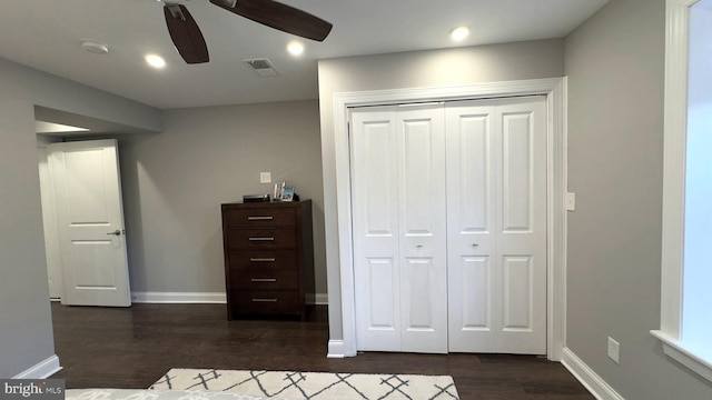 unfurnished bedroom featuring ceiling fan, dark hardwood / wood-style floors, and a closet