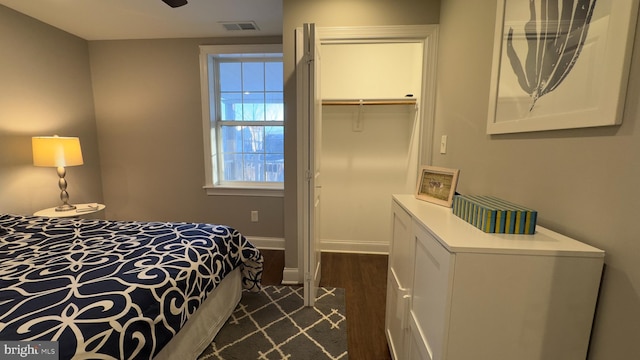 bedroom with dark hardwood / wood-style floors, a spacious closet, and a closet