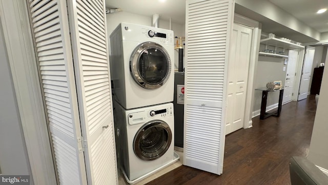 washroom with dark hardwood / wood-style floors and stacked washer / dryer