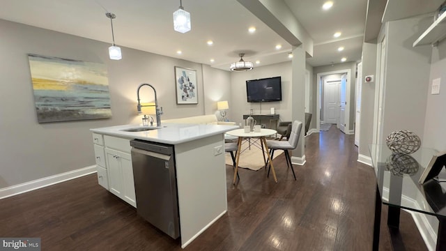 kitchen with stainless steel dishwasher, sink, pendant lighting, a center island with sink, and white cabinetry