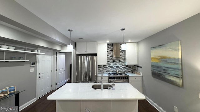 kitchen featuring white cabinetry, sink, wall chimney exhaust hood, hanging light fixtures, and stainless steel appliances