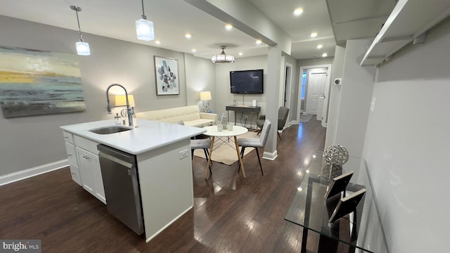 kitchen featuring sink, hanging light fixtures, stainless steel dishwasher, a center island with sink, and white cabinets