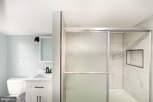 bathroom with vanity, toilet, and bath / shower combo with glass door