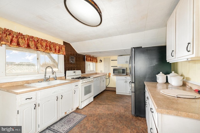 kitchen featuring a sink, appliances with stainless steel finishes, white cabinets, and light countertops