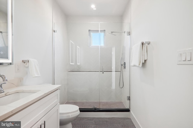 bathroom with toilet, vanity, and walk in shower