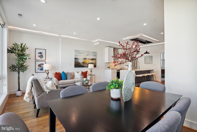 dining area featuring crown molding, light wood-type flooring, and sink