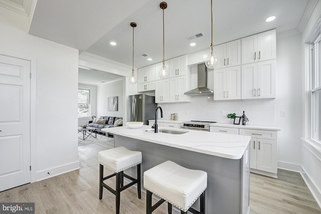 kitchen with white cabinetry, sink, wall chimney exhaust hood, and stainless steel appliances