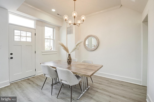 dining area with a chandelier, light hardwood / wood-style floors, and ornamental molding