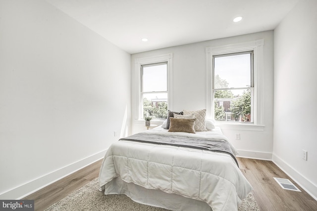 bedroom with light wood-type flooring and multiple windows