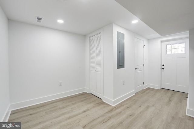 interior space featuring electric panel and light wood-type flooring