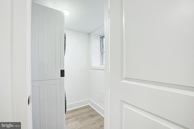 interior space featuring stacked washer and dryer and light hardwood / wood-style flooring