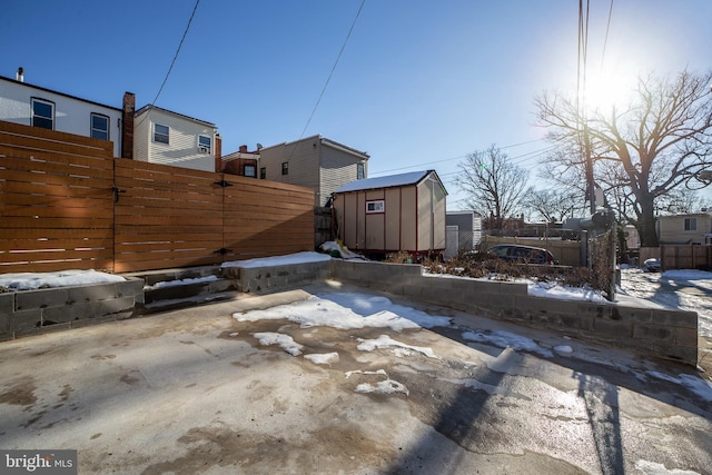 yard covered in snow featuring a shed