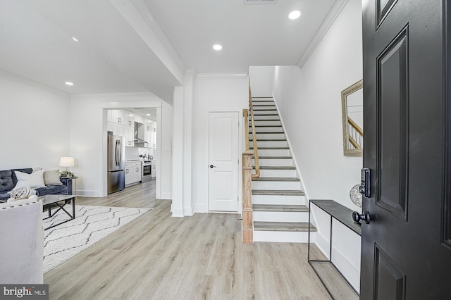 entrance foyer featuring light hardwood / wood-style floors and ornamental molding