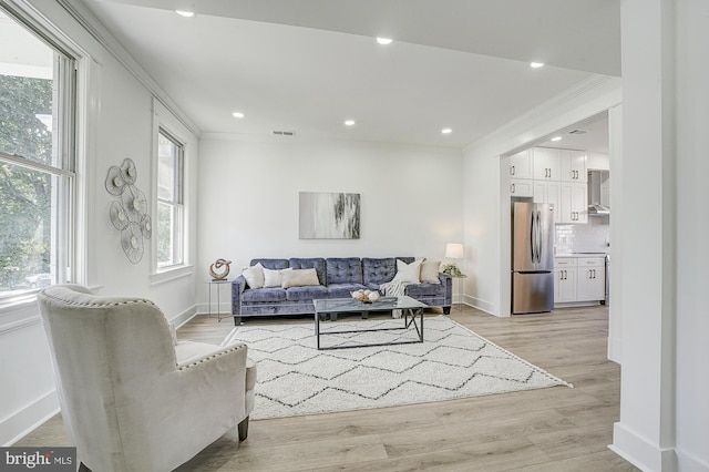 living room featuring light hardwood / wood-style flooring and ornamental molding