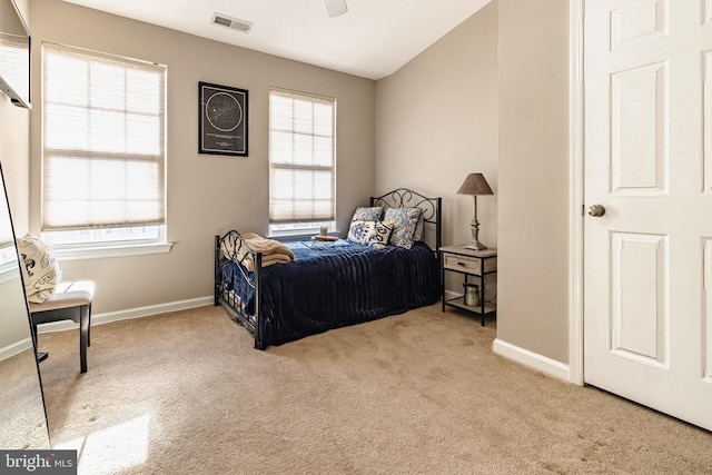 bedroom featuring multiple windows, ceiling fan, and light carpet