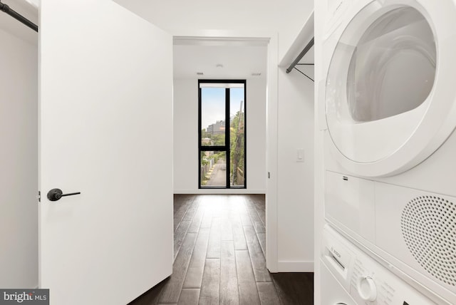 corridor featuring dark wood-type flooring and stacked washer / drying machine