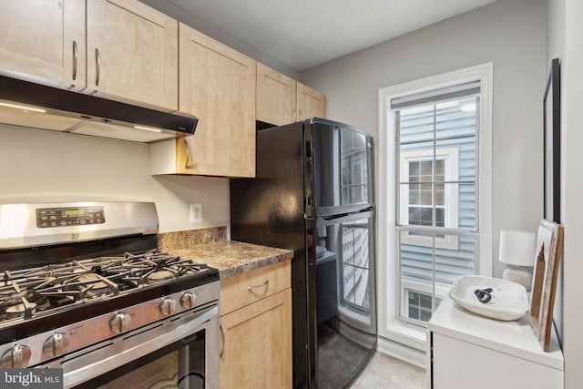 kitchen with light brown cabinets, black fridge, and stainless steel range with gas stovetop