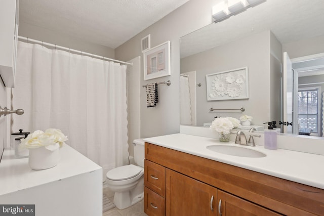 bathroom with a textured ceiling, toilet, vanity, and tile patterned flooring