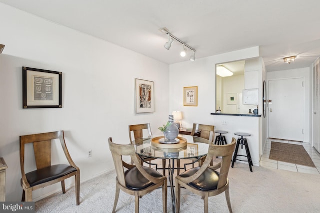 dining area featuring light colored carpet and track lighting