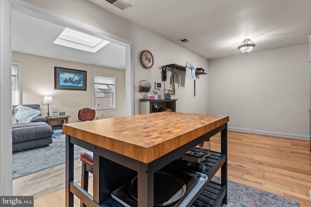 kitchen featuring light hardwood / wood-style floors and a skylight