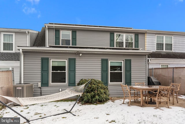 snow covered property featuring central AC