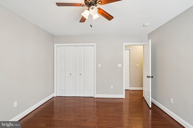 unfurnished bedroom with dark wood-type flooring, ceiling fan, and a closet