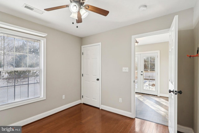 unfurnished bedroom with french doors, ceiling fan, and dark hardwood / wood-style flooring