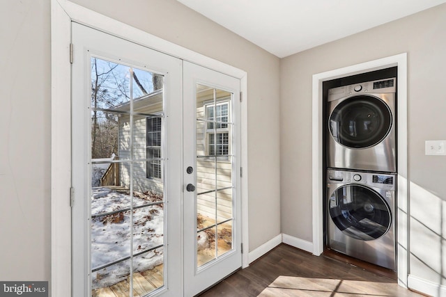 washroom featuring dark wood-type flooring, stacked washer and clothes dryer, and french doors