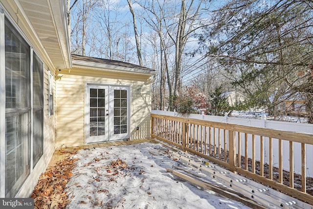 snow covered deck featuring french doors